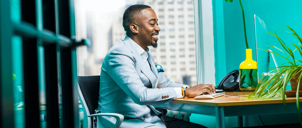 Man smiling typing on computer